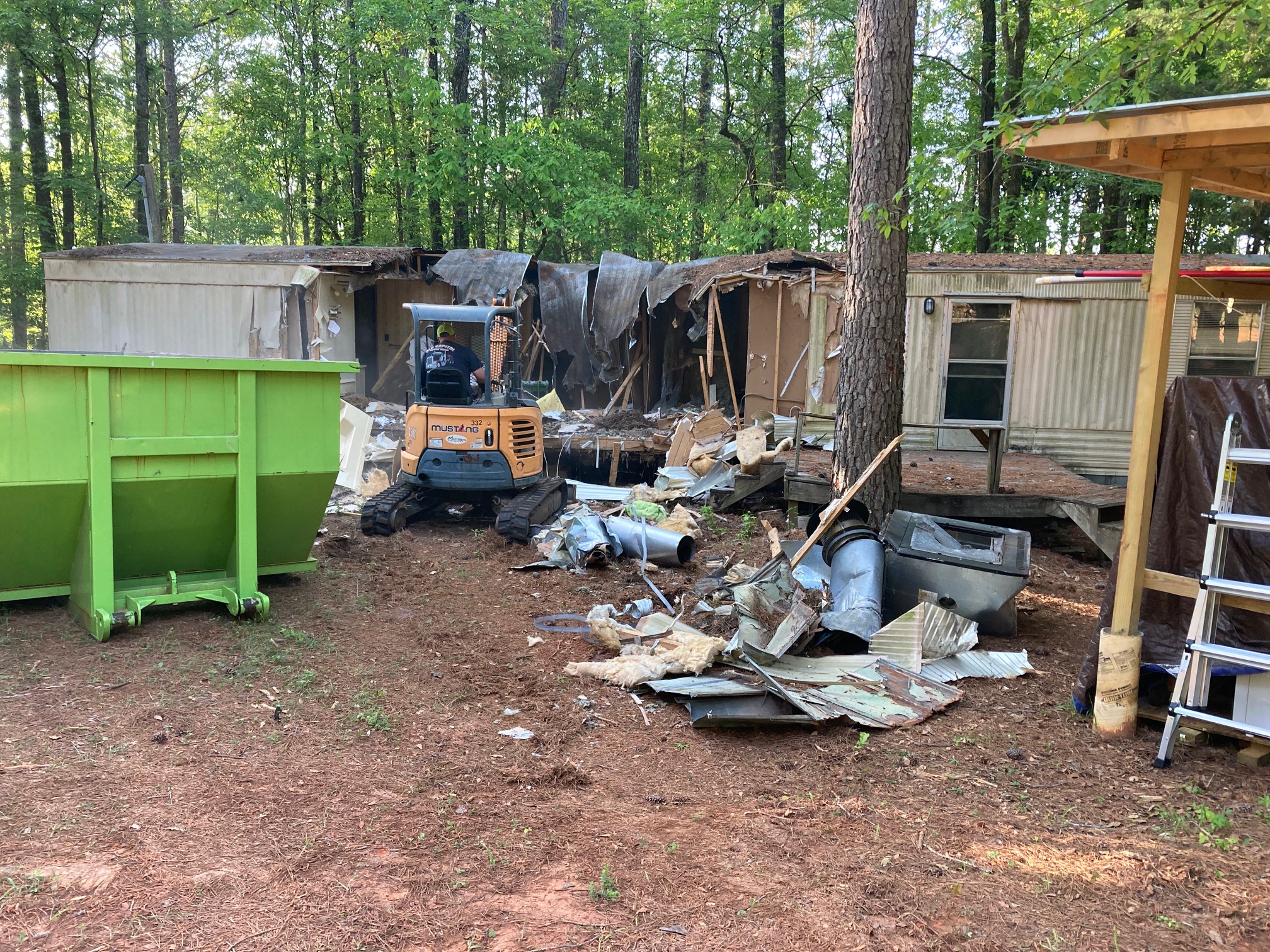 Mini excavator tearing down old mobile home for property cleanup in Sparta GA